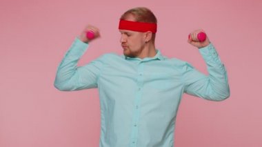 Genç bir adam tek başına halterlerle spor yapıyor. Kol kaslarını çalıştırıyor.