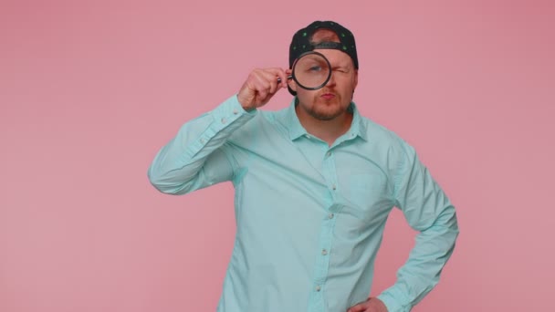 Forskare forskare man med förstoringsglas nära ansiktet, tittar in i kameran med stor zoom öga — Stockvideo
