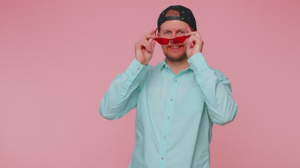 Lekfull lycklig man bär solglasögon blinkande öga tittar på kameran med leende, blinkande, flirtande — Stockvideo