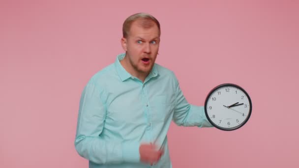 Confused man with anxiety checking time on clock, running late to work, being in delay, deadline — Stock Video