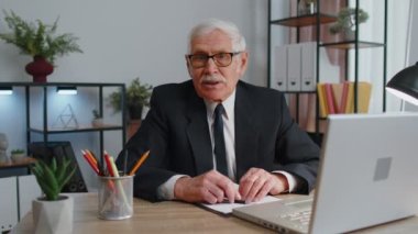 Kıdemli iş adamı kameraya uzanmış el sıkışma, selamlama, hoş geldin diyor.