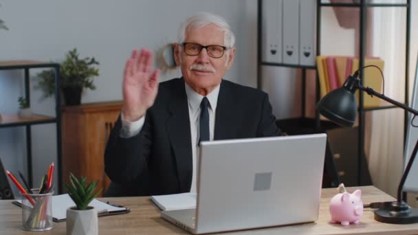 Sênior homem de negócios ondas mão palma em oi gesto saudação recebe alguém webinar em casa escritório — Vídeo de Stock