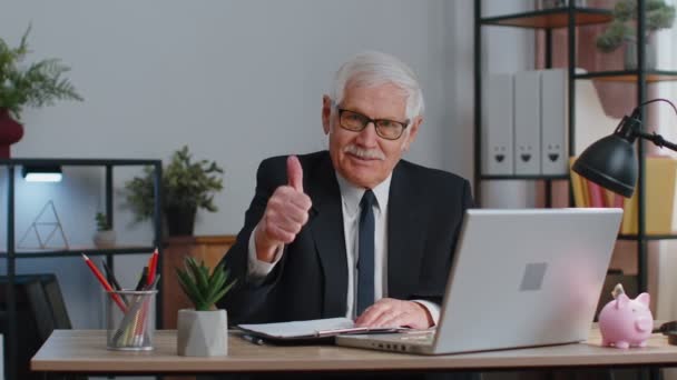 Senior zakenman steekt duimen op, stemt in, keurt goed, houdt van goed nieuws met laptop op kantoor — Stockvideo