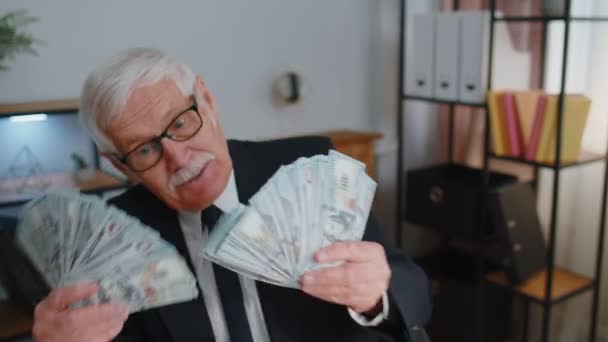 Бухгалтер-бизнесмен празднует успех бизнеса, танцуя со стопкой денег наличными — стоковое видео
