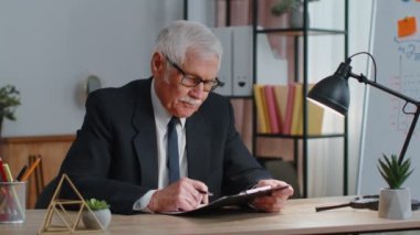 Migain baş ağrısından muzdarip dizüstü bilgisayar kullanan yorgun kıdemli işadamı serbest çalışan öğretmen.