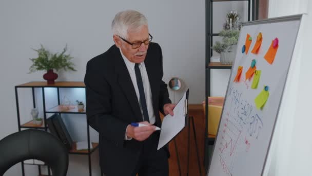 Senior business man coach leader conference speaker explain project strategy on office whiteboard — Vídeos de Stock