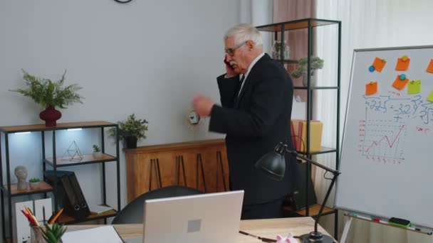 Öfkeli kıdemli iş adamı ofis telefonlarına bakıyor. Patron sinirli bir şekilde telefonda tartışıyor. — Stok video