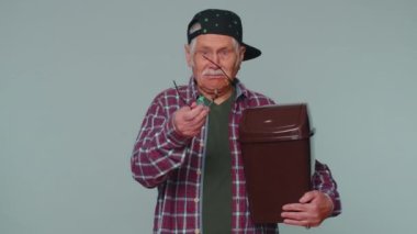 Smiling senior man taking off, throwing out glasses into bin after vision laser treatment therapy