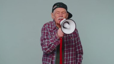 Gülümseyen bıyıklı adam megafonla konuşuyor. Satış reklamını yüksek sesle duyuruyor.