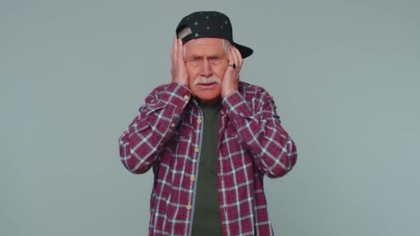Frustrerad irriterad äldre man täcker öronen, undvika råd ignorera obehagliga ljud höga röster — Stockvideo