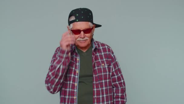 Seductive cheerful stylish senior old man in shirt wearing sunglasses, charming smile on pink wall — Stok video