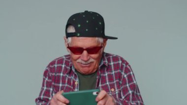 Endişeli komik bağımlı son sınıf öğrencisi cep telefonuyla yarış oyunları oynuyor.