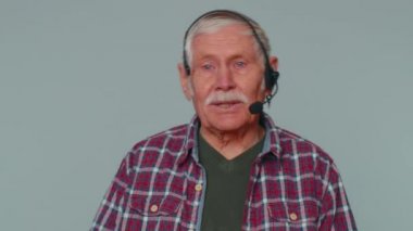 Senior man wearing headset freelance worker call center or support service operator helpline talk