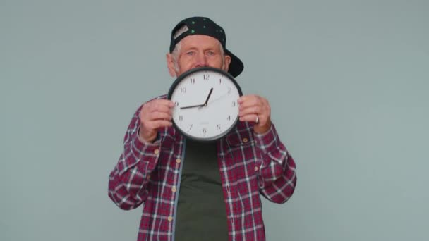 Senior man holding clock watch, hiding, checking time on clock, running late to work being in delay — Stock Video