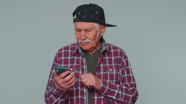 Hombre mayor que utiliza el teléfono móvil escribiendo post en la web SMS mensaje de navegación adicción a las redes sociales — Vídeo de stock