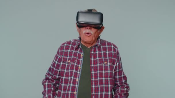 Homem usando tecnologia futurista realidade virtual VR capacete de fone de ouvido para jogar simulação 3D vídeo game — Vídeo de Stock