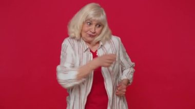 Senior old woman making fight threat at camera shaking fist punch, boxing with expression punishment