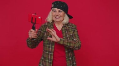 Kadın blogcu cep telefonu özçekim çubuğu iletişim videosu abonesiyle çevrimiçi olarak selfie çekiyor