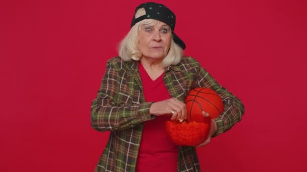 Anziani anziani fan di basket vecchia donna mangiare popcorn facendo gesto vincitore, celebrando vittoria vincere — Video Stock