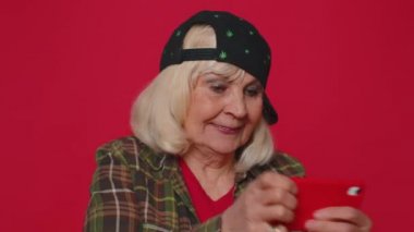 Endişeli komik bağımlı son sınıf kadını hevesle cep telefonuyla yarış oyunları oynuyor.