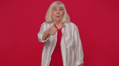 Kıdemli stil sahibi, tişörtlü yaşlı kadın başparmağını sallıyor ve onaylıyor, başarılı bir iş.