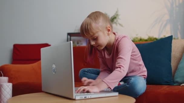 小さな子供の女の子が熱狂的に自宅でラップトップPC仮想現実シューティングゲーム — ストック動画