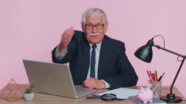 Starszy biznesmen z biura patrzący na kamerę, wykonujący gest telefoniczny. — Wideo stockowe