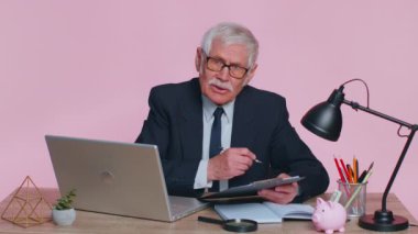 Kıdemli iş adamı direktörü iş görüşmesi yapıyor. Pembe ofiste video konferans görüşmesi.