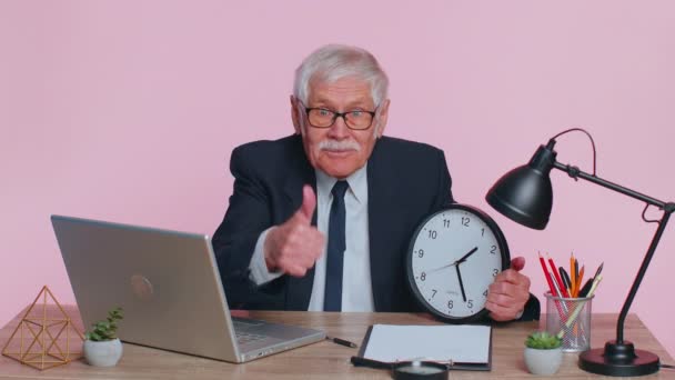 Empresário sorridente sênior mostrando o tempo na parede relógio de escritório, ok, polegar para cima, bom aprovar o sucesso — Vídeo de Stock