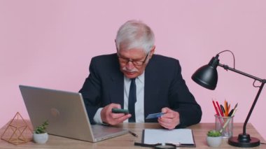 Banka kartı ve akıllı telefon kullanan kıdemli işadamı, para transferi ve alımları İnternet üzerinden yapıyor.