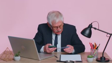 Banka kartı ve akıllı telefon kullanan kıdemli işadamı, para transferi ve alımları İnternet üzerinden yapıyor.