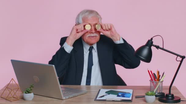 Oudere zakenman toont gouden Bitcoins BTC, geld mijnbouw, investeringen, rijkdom, verdienen, inkomen — Stockvideo