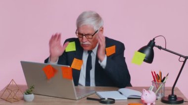 Dizüstü bilgisayarlı yorgun kıdemli işadamı ofis müdürü bir sürü işi olan yapışkan notlar yapıştırıyor.