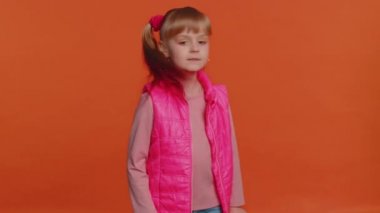 Girl child presses index finger to lips makes silence gesture sign do not tells secret, shh be quiet