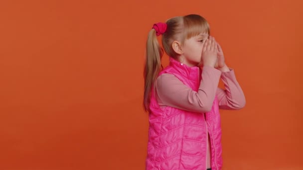 Leksaksflicka ler vänligt mot kameran och viftar med händerna gestikulerande hej eller adjö, välkomnande — Stockvideo