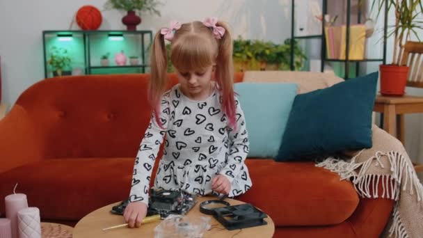 Little girl kid fixing repairing computer mainboard technology part, using magnifying glass at home — 비디오