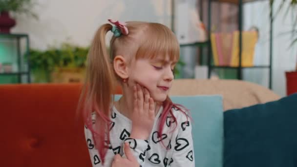 Тоддлер ребенок девочка трогает щеку, ужасно страдают от боли в зубах, чувствительные зубы, кариес — стоковое видео