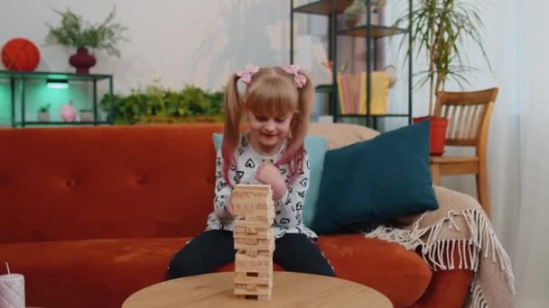 Happy little one teen kid girl play wooden tower blocks bricks game at home in modern living room — Αρχείο Βίντεο
