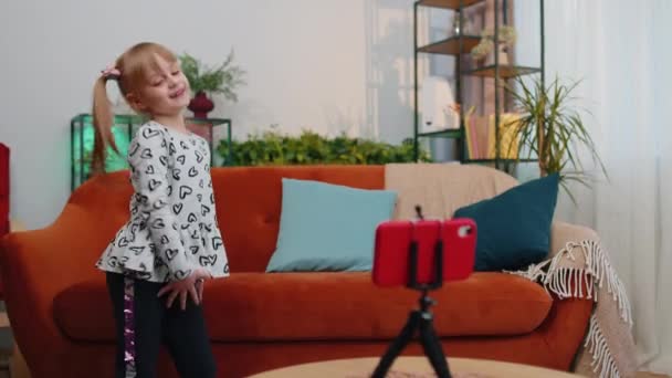 Dziecko dziecko dziecko dziewczyna blogger influencer robi taniec wideo dla sieci mediów społecznościowych na smartfonie w domu — Wideo stockowe