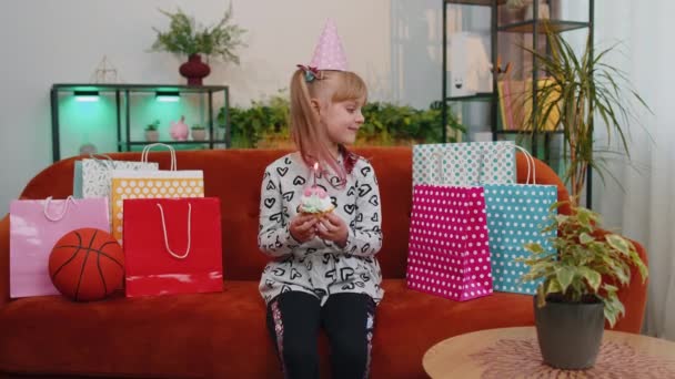 Young little children girl sitting on sofa with lots of gifts celebrating birthday party anniversary — Vídeos de Stock
