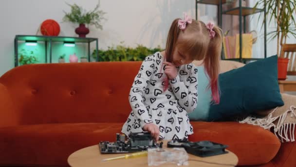 Petite fille adolescente intelligente avec tournevis réparation ordinateur carte mère ventilateur électronique à la maison — Video