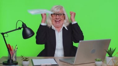Senior rich businesswoman dancing celebrate win enjoy wealth lots of money dollar cash rain falling