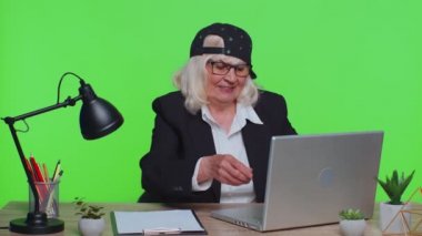 Senior business woman raises thumbs up, agrees, approve, likes good news using laptop at office