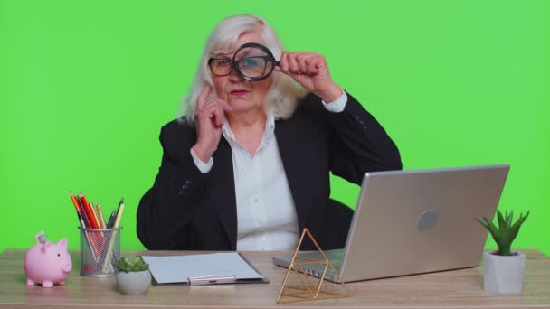 Investigator senior femeie de afaceri deține lupă de sticlă aproape de față uitându-se cu ochi mari zoom amuzant — Videoclip de stoc