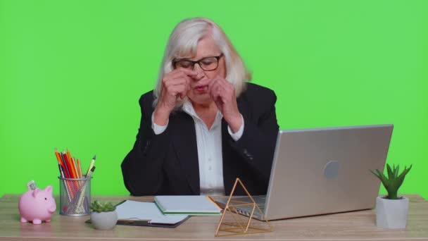Cansada mujer de negocios senior cansada se quita las gafas siente dolor en los ojos estar agotando el trabajo somnoliento — Vídeos de Stock