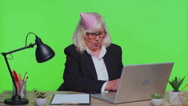 Triste bouleversé solitaire senior femme d'affaires célébrant fête d'anniversaire seul, tient gâteau au bureau vert — Video