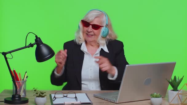 Donna d'affari anziana che ascolta musica con le cuffie, balla disco scherzando, festeggia la vittoria — Video Stock