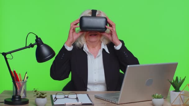 Senior businesswoman using headset helmet app to play simulation game watching virtual reality video — Stock video