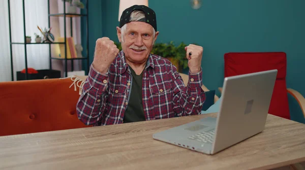 Overjoyed senior grandfather man with laptop celebrate success win money in lottery online good news — Stock Photo, Image