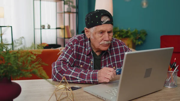 Senior grandfather man typing credit cards information on laptop, making internet online shopping — Stock Photo, Image